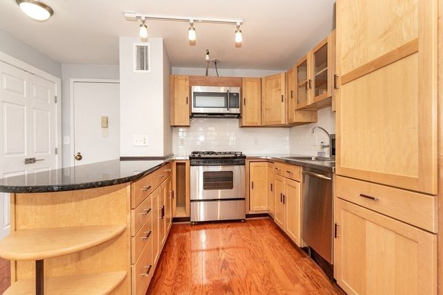 a kitchen with granite countertop a stove and a sink
