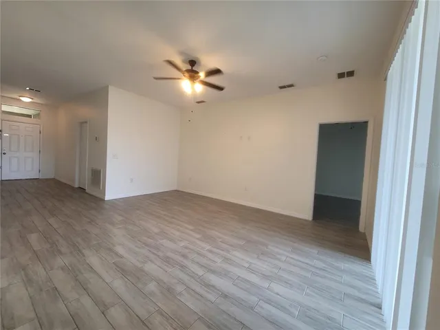 a view of an empty room with wooden floor