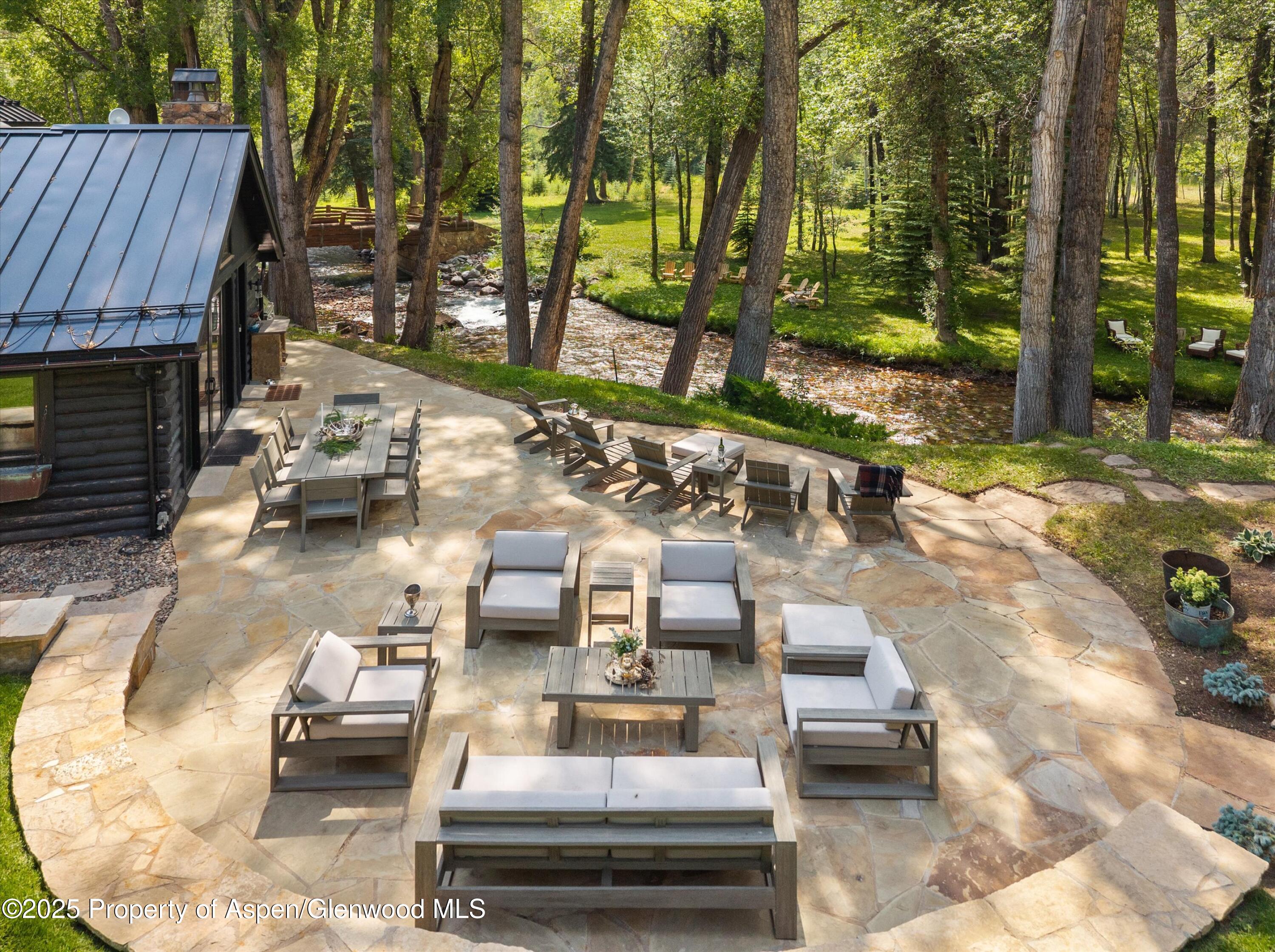6458 Snowmass Creek Road Snowmass, CO 81654 - Photo 27 of 114 a view of a patio with table and chairs potted plants and large tree