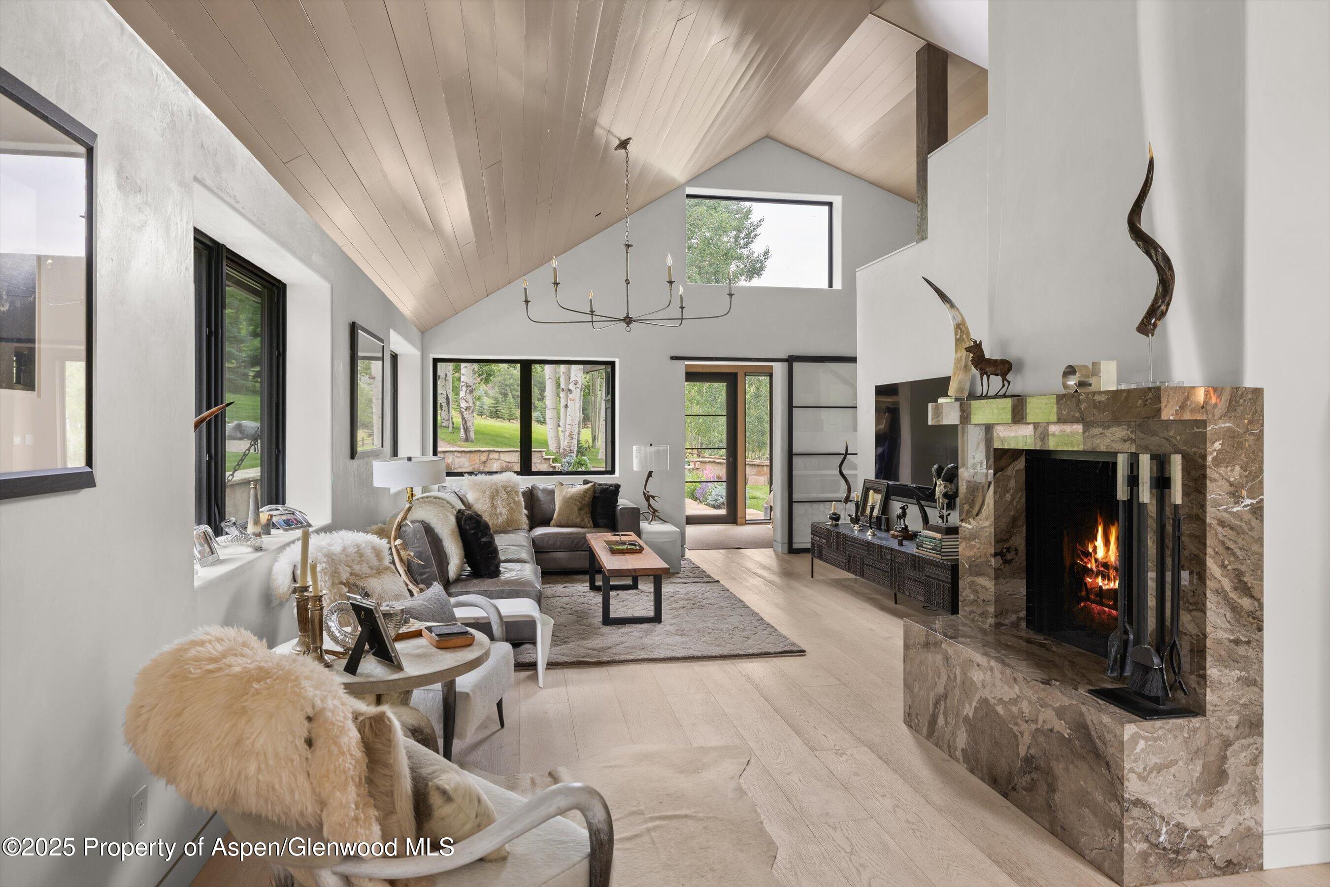 6458 Snowmass Creek Road Snowmass, CO 81654 - Photo 39 of 114 a living room with furniture a fireplace and a chandelier