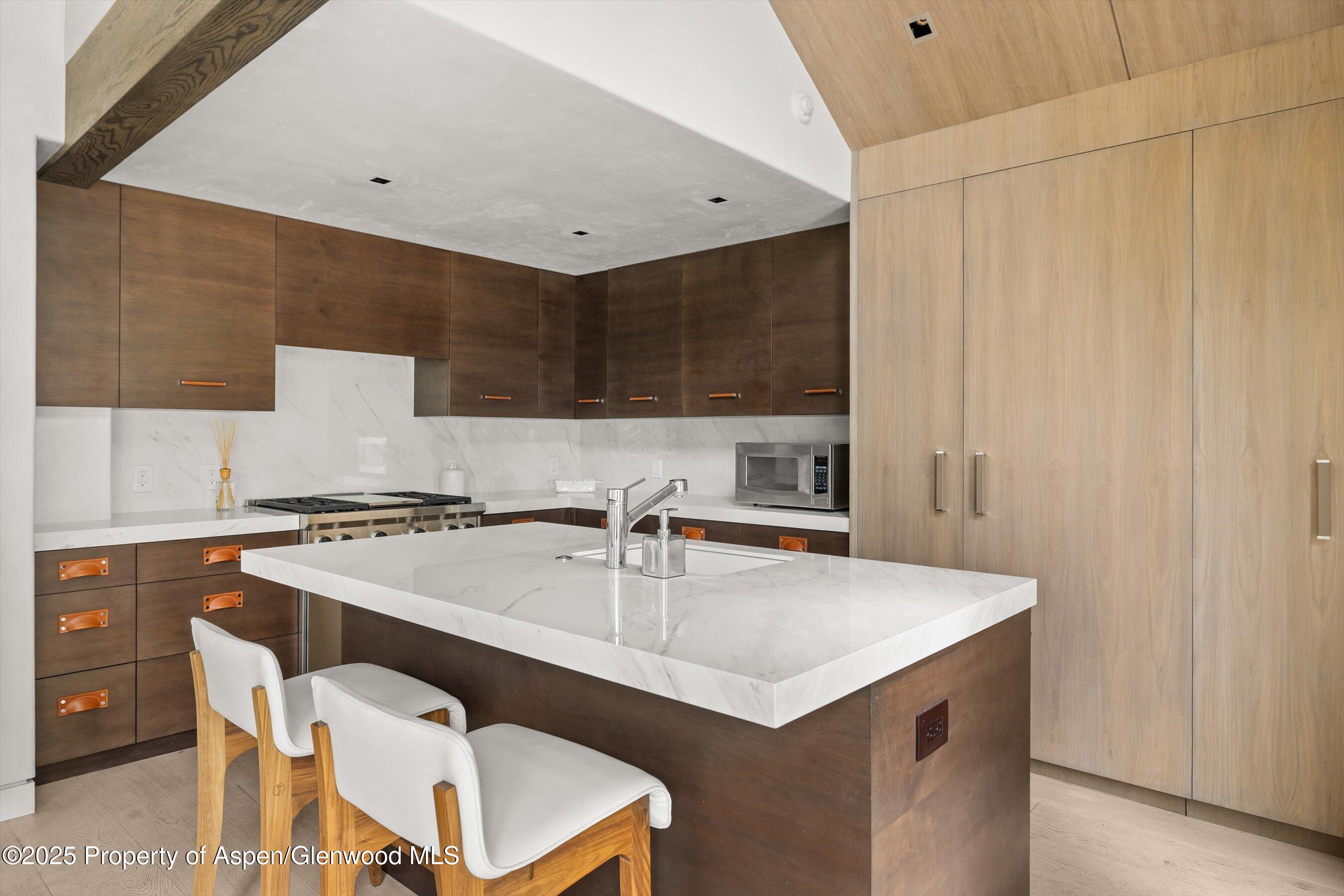 6458 Snowmass Creek Road Snowmass, CO 81654 - Photo 46 of 114 a kitchen with a sink a stove a refrigerator and white cabinets