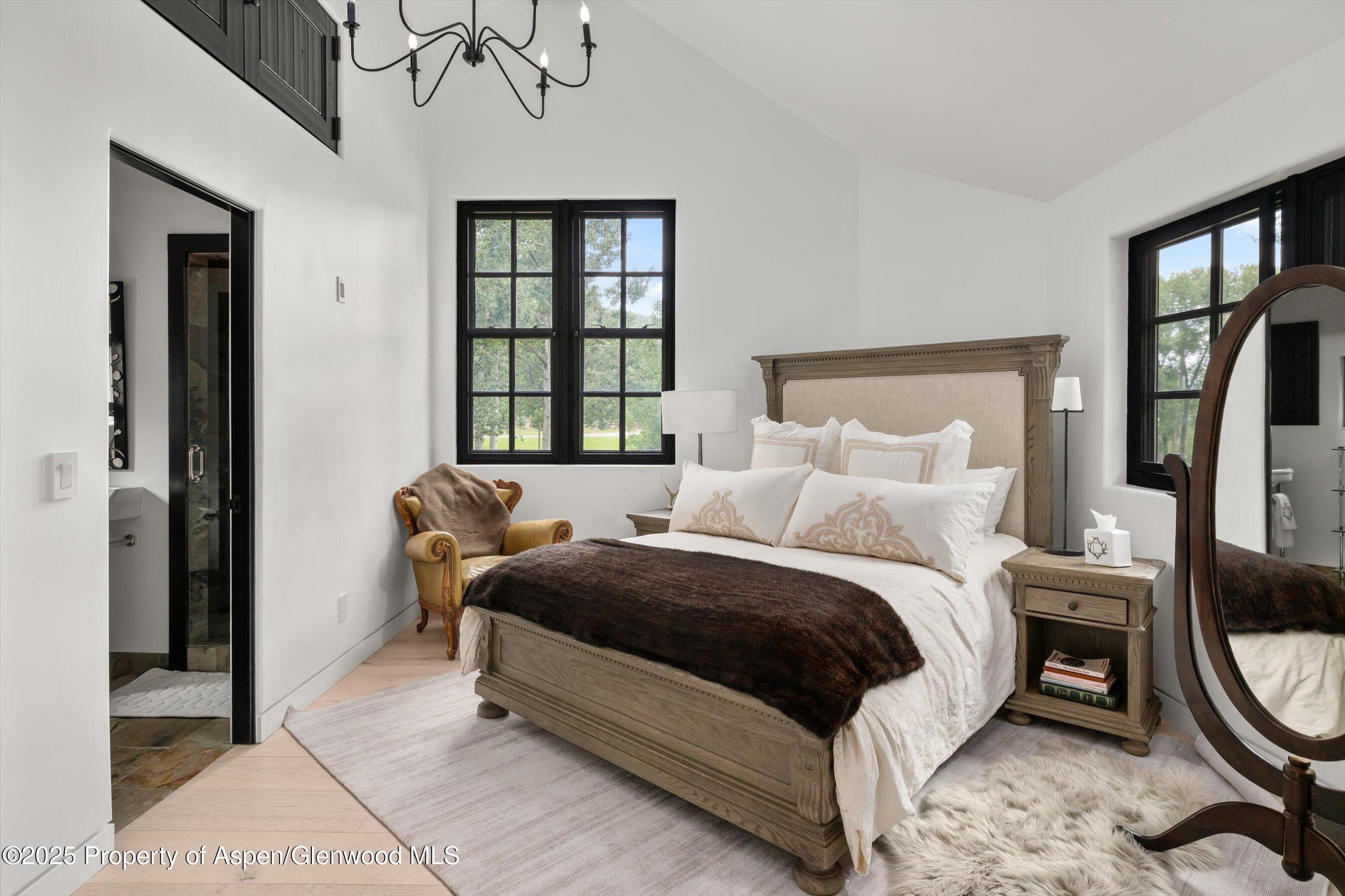 6458 Snowmass Creek Road Snowmass, CO 81654 - Photo 56 of 114 a bedroom with a bed a mirror and a large window