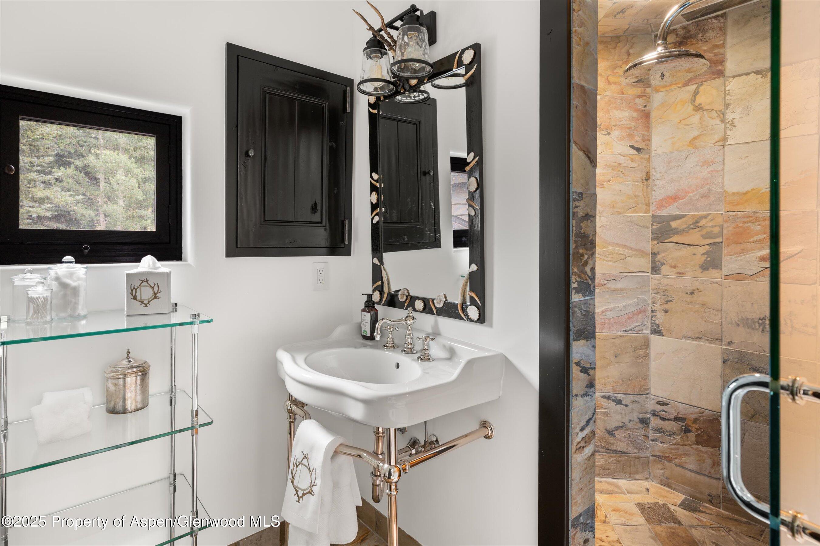 6458 Snowmass Creek Road Snowmass, CO 81654 - Photo 57 of 114 a bathroom with a sink a mirror and a shower
