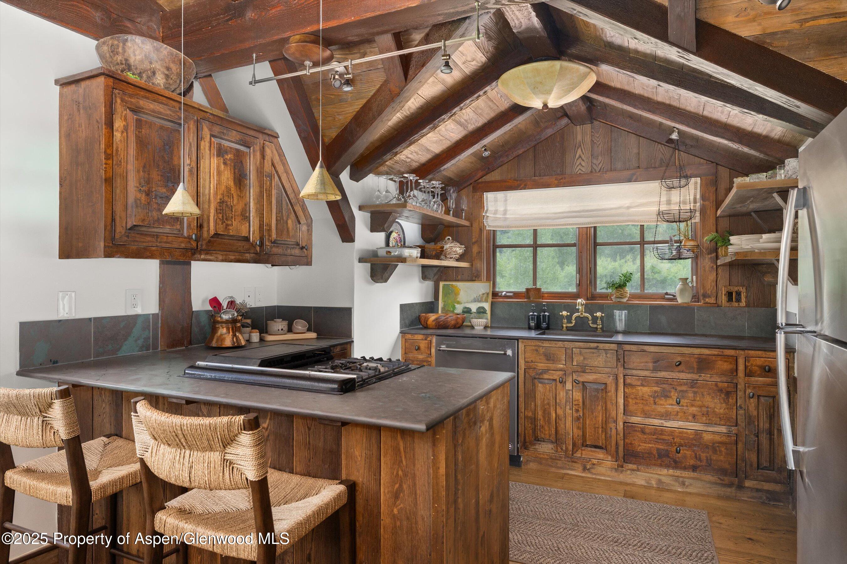 6458 Snowmass Creek Road Snowmass, CO 81654 - Photo 80 of 114 a kitchen with stainless steel appliances granite countertop a sink a stove and a wooden cabinets