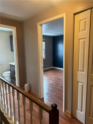 a view of a hallway with wooden floor and entryway