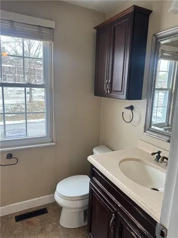 a bathroom with a sink a toilet and window