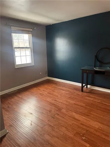 a view of room with wooden floor and windows