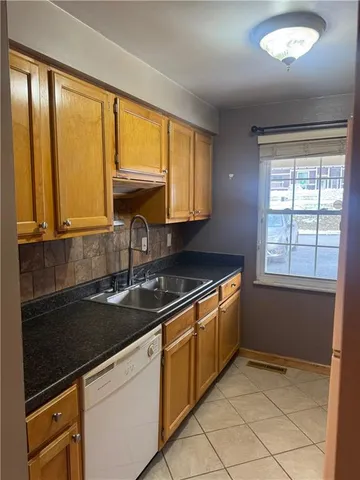 a kitchen with granite countertop a sink and a stove