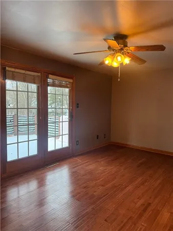 a view of an empty room with glass window and chandelier