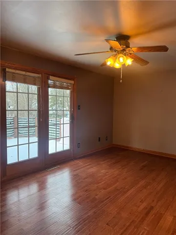 a view of an empty room with glass window and chandelier