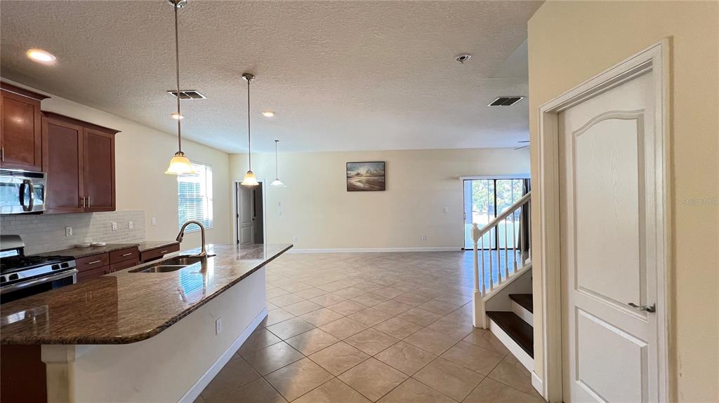 15401 Porter Road Winter Garden, FL 34787 - Photo 25 of 59 a kitchen with granite countertop a sink a counter top space and cabinets