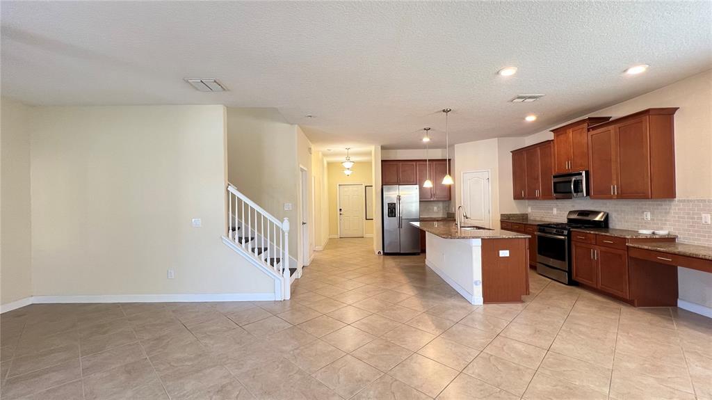 15401 Porter Road Winter Garden, FL 34787 - Photo 35 of 59 a large kitchen with stainless steel appliances granite countertop a stove a sink a refrigerator and a microwave