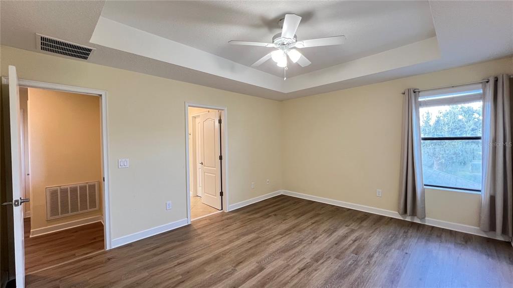15401 Porter Road Winter Garden, FL 34787 - Photo 41 of 59 an empty room with wooden floor chandelier fan and windows