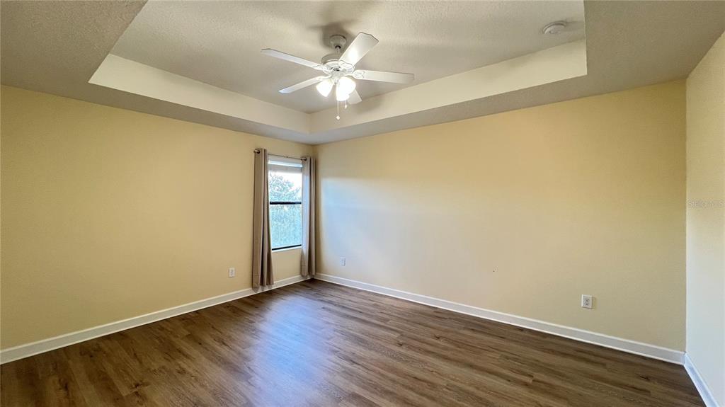 15401 Porter Road Winter Garden, FL 34787 - Photo 42 of 59 an empty room with wooden floor and fan