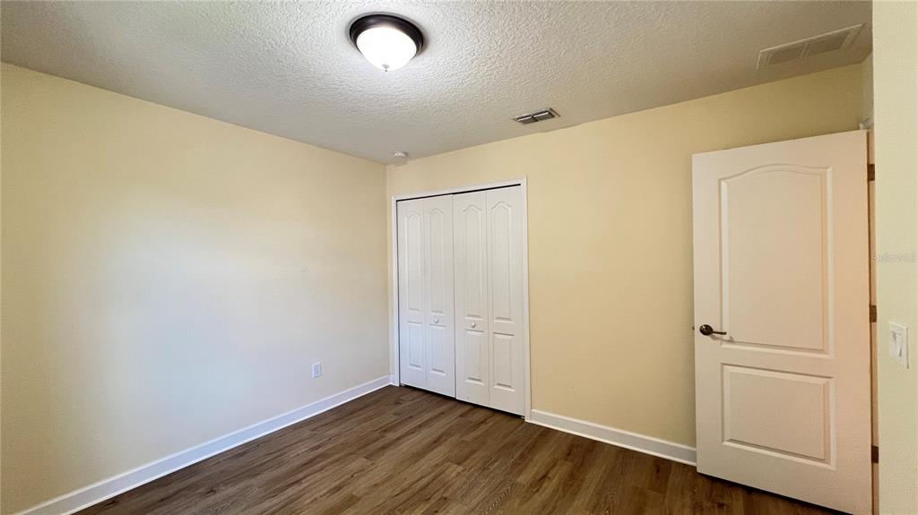 15401 Porter Road Winter Garden, FL 34787 - Photo 54 of 59 an empty room with wooden floor and white walls