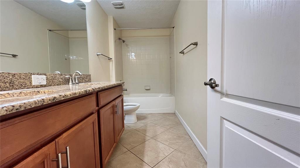 15401 Porter Road Winter Garden, FL 34787 - Photo 56 of 59 a bathroom with a granite countertop sink a toilet and shower