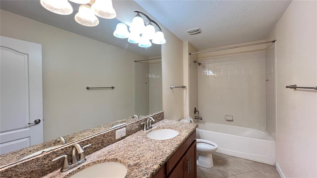 15401 Porter Road Winter Garden, FL 34787 - Photo 57 of 59 a bathroom with a granite countertop sink a mirror and a bathtub