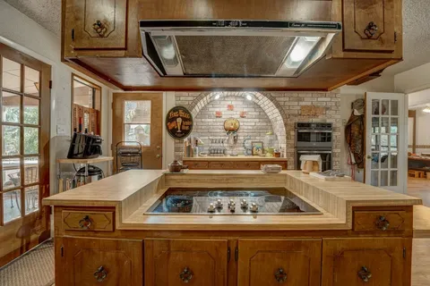 a large kitchen with stainless steel appliances kitchen island granite countertop a large kitchen island and a refrigerator