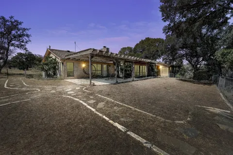 a view of a brick house with wooden fence