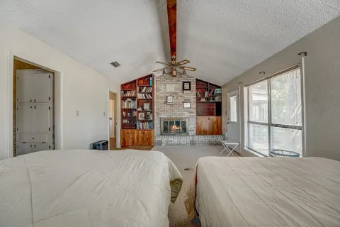a bed sitting in a spacious bedroom next to a window