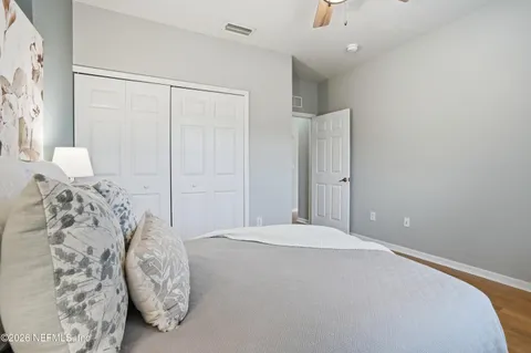 a bedroom with a bed and a white wall painting