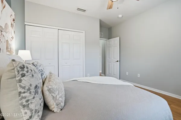 a bedroom with a bed and a white wall painting