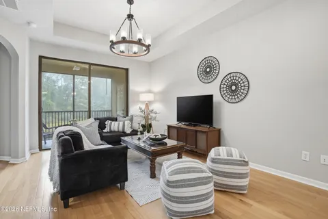 a living room with furniture a flat screen tv and a large window