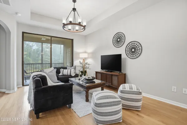 a living room with furniture a flat screen tv and a large window