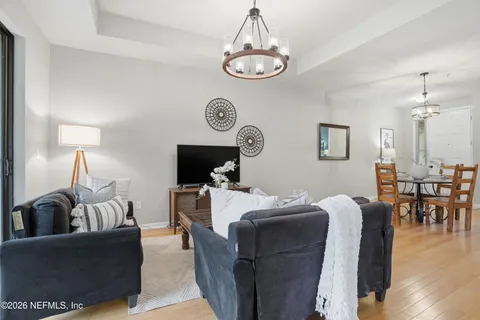 a living room with couches a table and chairs with wooden floor