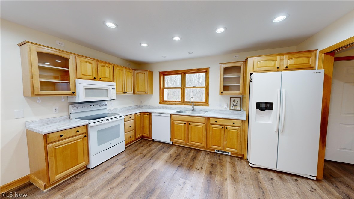 15548 Trask Road Thompson, OH 44086 - Photo 11 of 31 Kitchen featuring light hardwood / wood-style floors, white appliances, and sink
