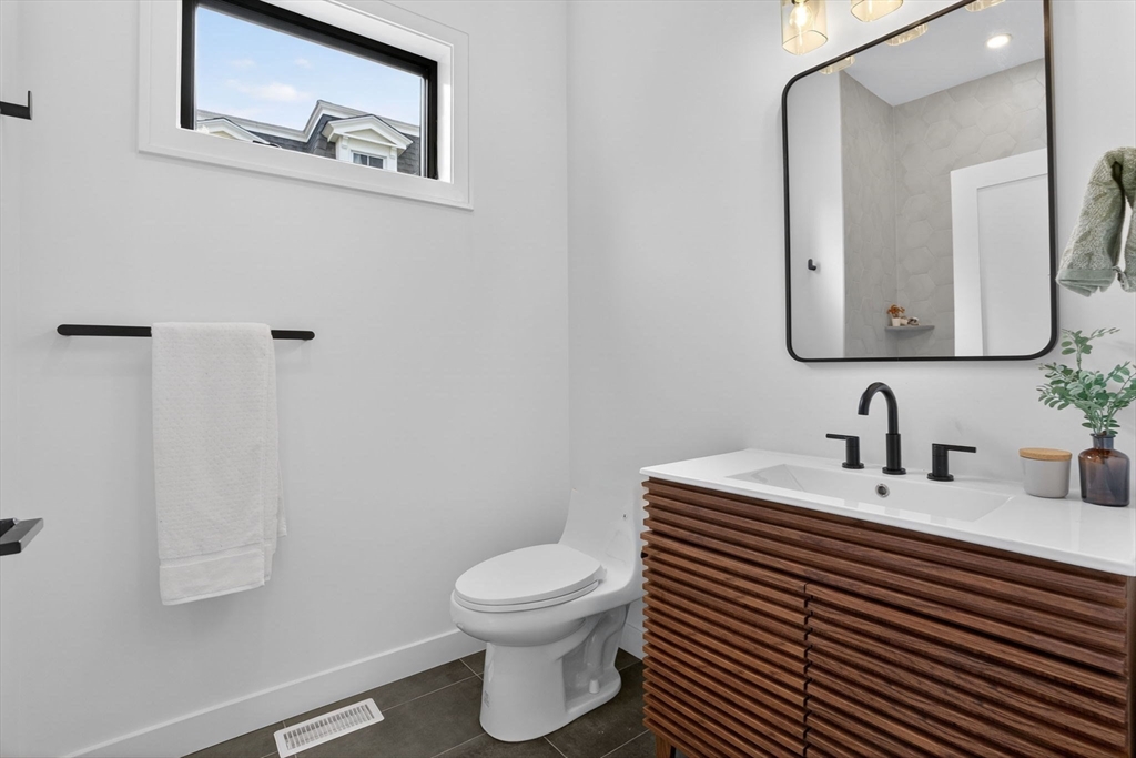 14 Hamlet Street, Unit A Somerville, MA 02143 - Photo 11 of 22 a bathroom with a toilet a sink and mirror