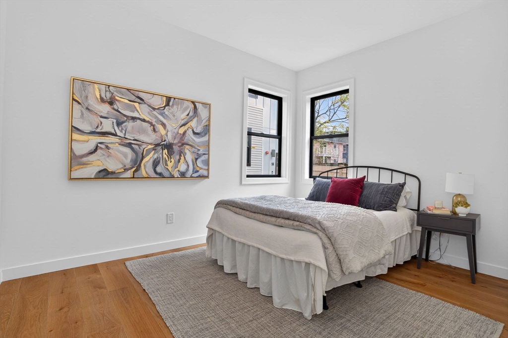 14 Hamlet Street, Unit A Somerville, MA 02143 - Photo 13 of 22 a bedroom with a large bed and a wall painting