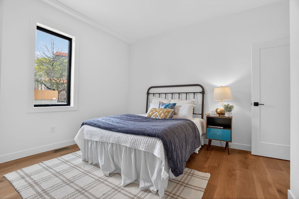 14 Hamlet Street, Unit A Somerville, MA 02143 - Photo 10 of 22 a bedroom with a bed and wooden floor