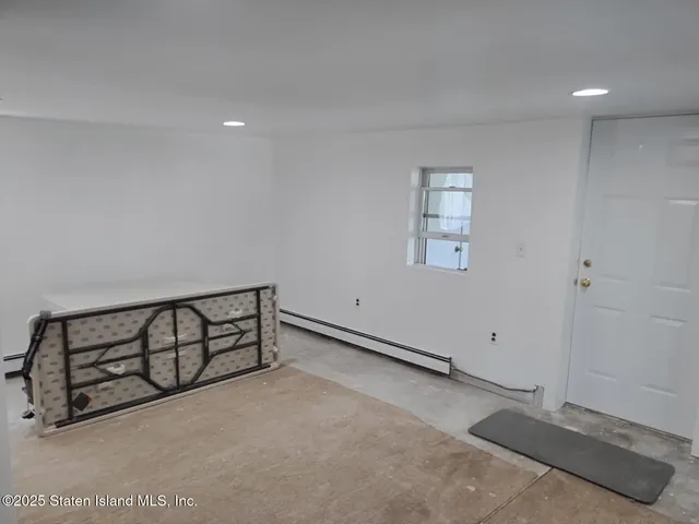 a view of an empty room with window and closet area