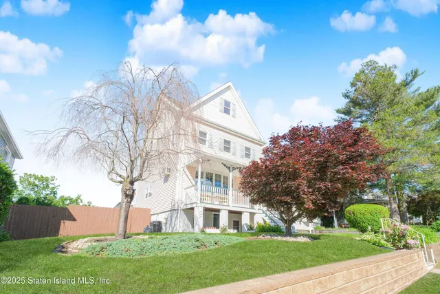 a view of a big building with a big yard and large trees