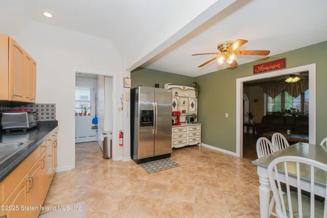 a kitchen with stainless steel appliances granite countertop a stove top oven a sink a dining table and chairs