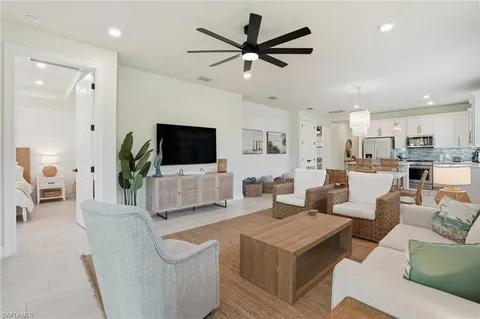a living room with furniture kitchen view and a flat screen tv