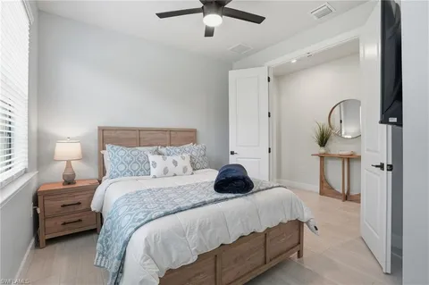 a bedroom with a bed a mirror and lamp