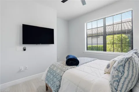 a bedroom with a bed and a flat tv screen on the dresser