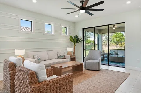 a living room with furniture and a floor to ceiling window