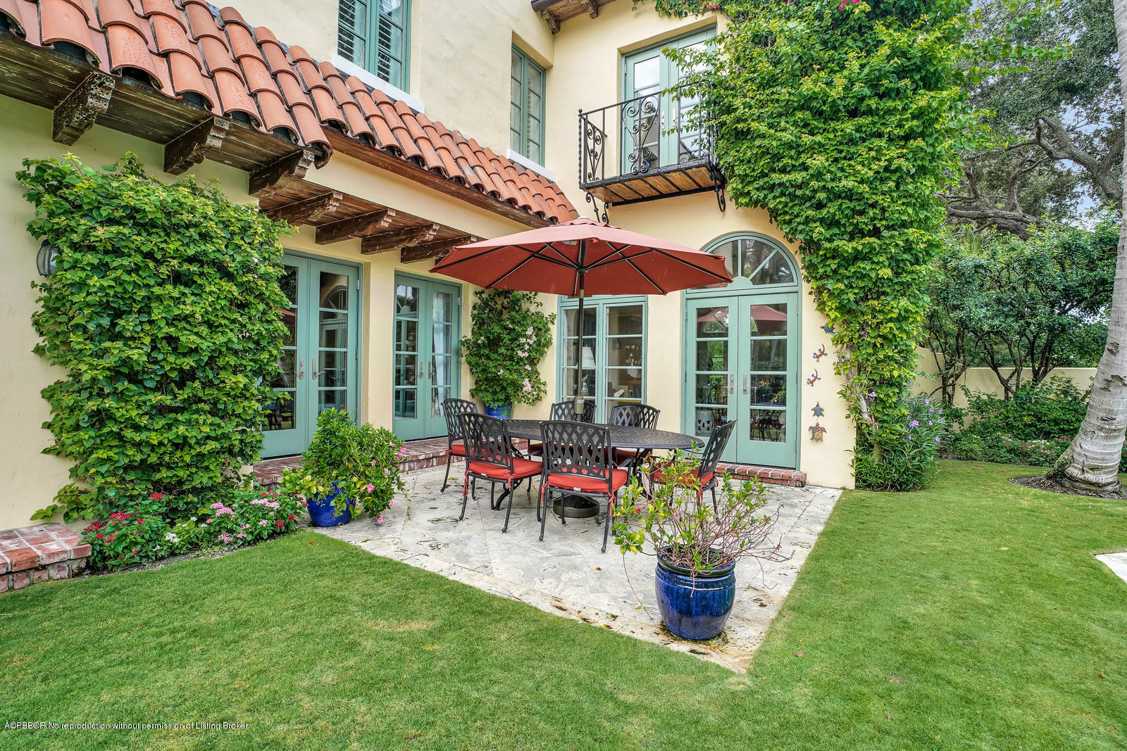 258 Wells Road Palm Beach, FL 33480 - Photo 14 of 18 a patio with a table and chairs under an umbrella