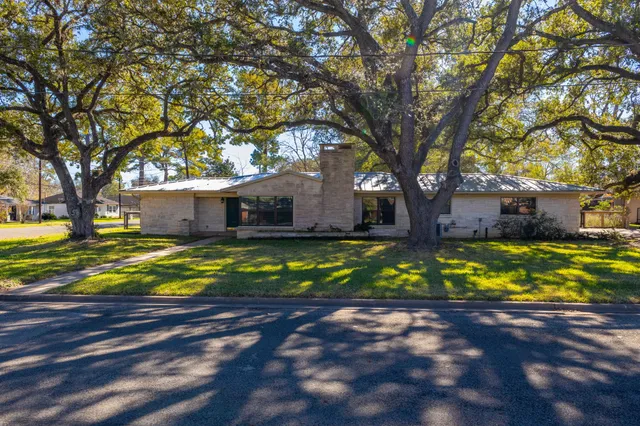 a view of a house with large trees