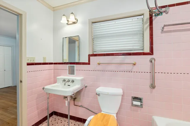 a bathroom with a toilet sink and mirror