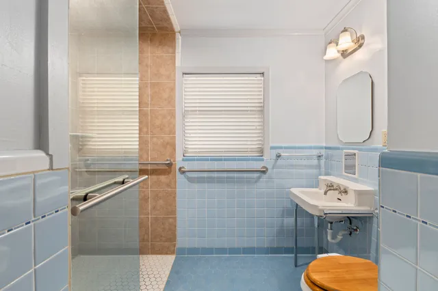 a bathroom with a sink a toilet and a mirror