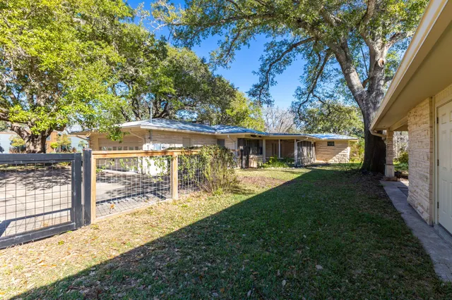 a view of a house with backyard and a tree