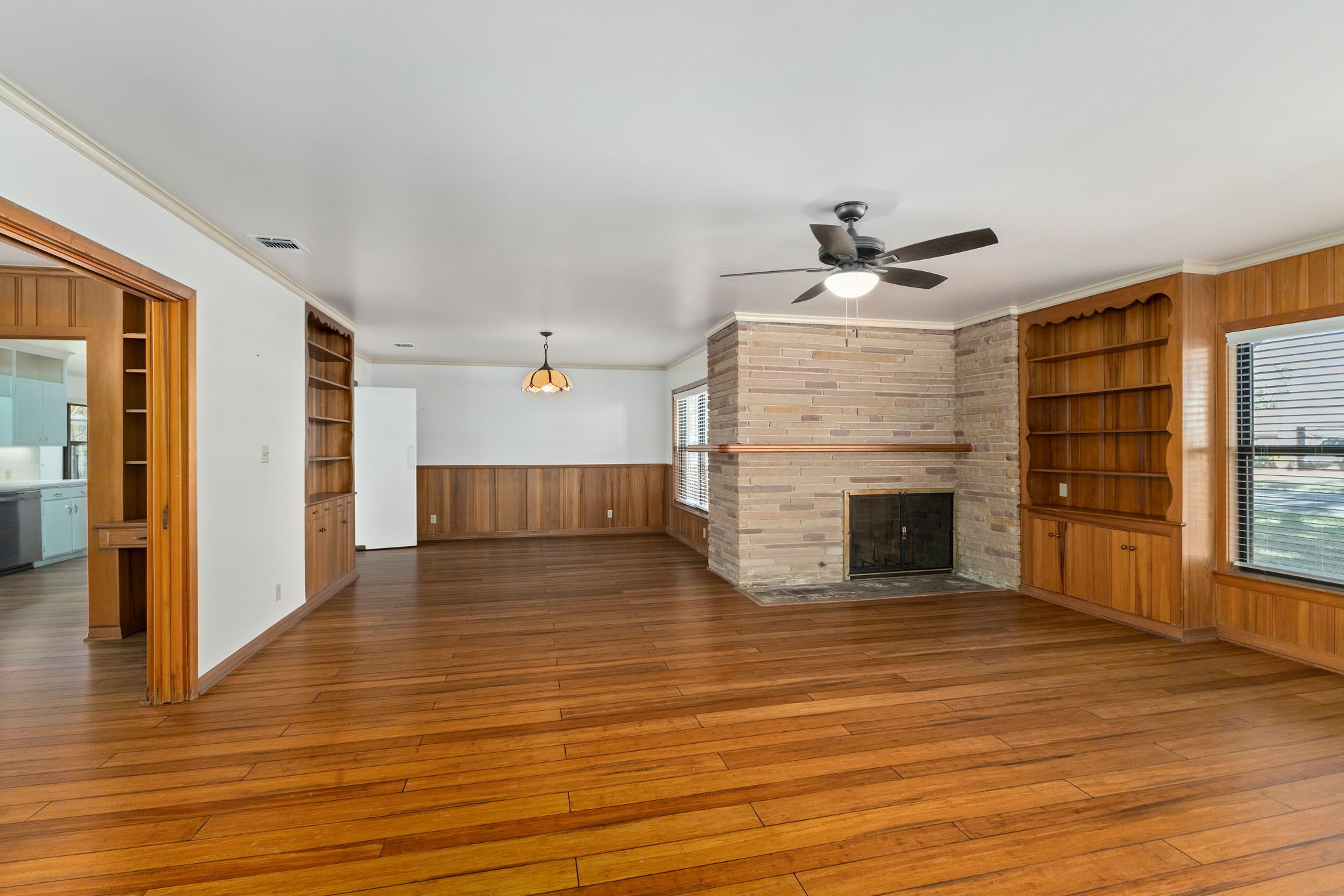 301 Bonham Street Columbus, TX 78934 - Photo 4 of 44 a view of a livingroom with wooden floor and a ceiling fan