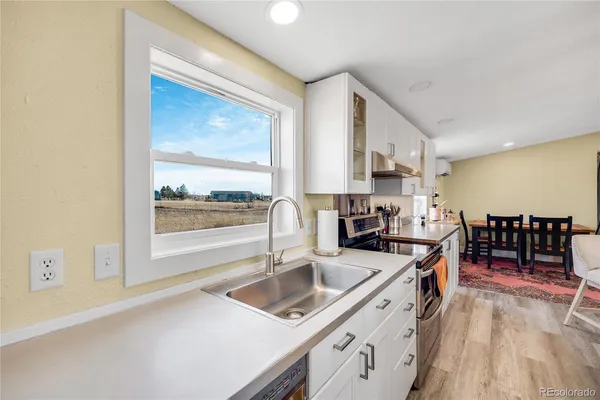 a kitchen that has a sink a stove counter top space and cabinets
