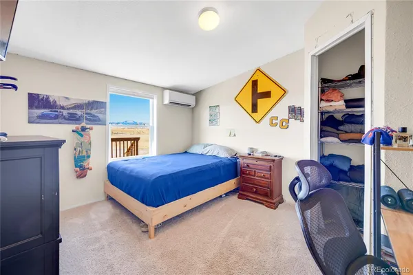 a bedroom with a bed and painting on the wall