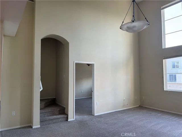 a view of empty room with window and wooden floor