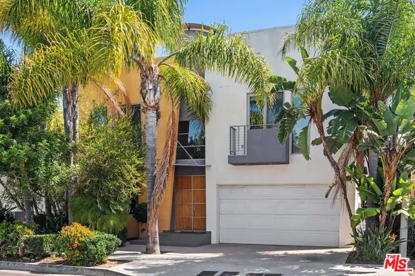 a front view of a house with a tree
